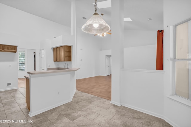 96428 Chester Rd, Yulee, FL 32097 - kitchen featuring high vaulted ceiling, open shelves, a peninsula, brown cabinets, and light countertops