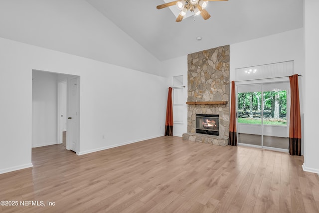 96428 Chester Rd, Yulee, FL 32097 - unfurnished living room with high vaulted ceiling, a ceiling fan, a stone fireplace, wood finished floors, and baseboards