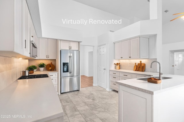 96428 Chester Rd, Yulee, FL 32097 - kitchen with stainless steel refrigerator with ice dispenser, tasteful backsplash, cooktop, a sink, and light marble finish floors
