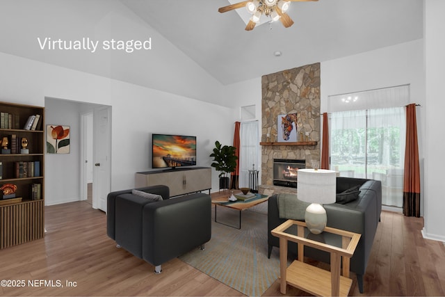 96428 Chester Rd, Yulee, FL 32097 - living area featuring high vaulted ceiling, ceiling fan, wood finished floors, a stone fireplace, and baseboards