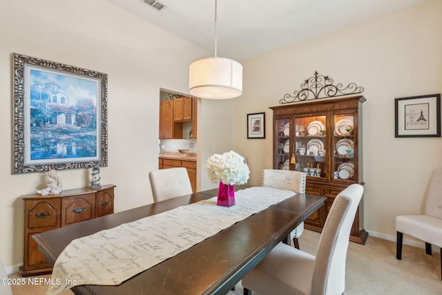 dining room with light carpet and baseboards