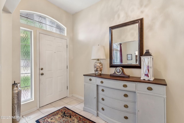 entrance foyer featuring light tile patterned floors, healthy amount of natural light, and baseboards