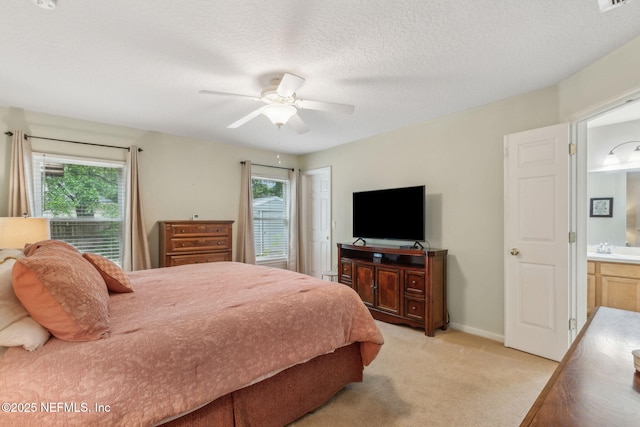 bedroom with multiple windows, light carpet, baseboards, a ceiling fan, and a textured ceiling