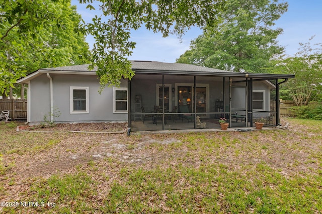 back of property featuring fence and a sunroom