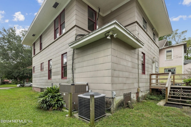 2143 Myra St, Jacksonville, FL 32204 - view of side of home with cooling unit, a wooden deck, and a lawn