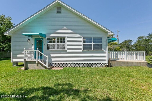 3060 Lewis Speedway, Saint Augustine, FL 32084 - rear view of property with a lawn and a wooden deck