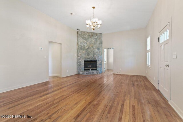 3060 Lewis Speedway, Saint Augustine, FL 32084 - unfurnished living room featuring a chandelier, wood finished floors, baseboards, and a fireplace