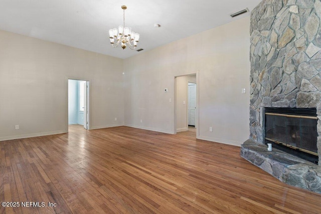 3060 Lewis Speedway, Saint Augustine, FL 32084 - unfurnished living room with a chandelier, wood finished floors, a stone fireplace, and baseboards
