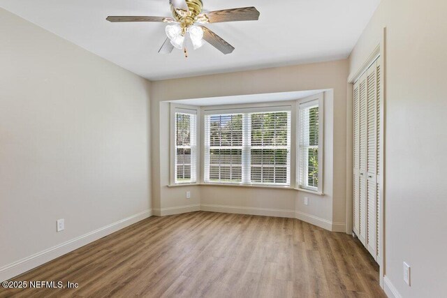 3060 Lewis Speedway, Saint Augustine, FL 32084 - unfurnished bedroom featuring wood finished floors, baseboards, a closet, and a ceiling fan