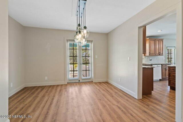3060 Lewis Speedway, Saint Augustine, FL 32084 - unfurnished dining area featuring light wood-type flooring, baseboards, and a chandelier