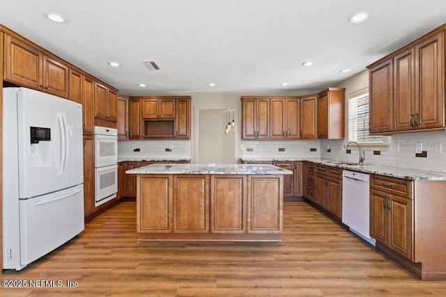 3060 Lewis Speedway, Saint Augustine, FL 32084 - kitchen featuring white appliances, a sink, a center island, light wood-style floors, and recessed lighting