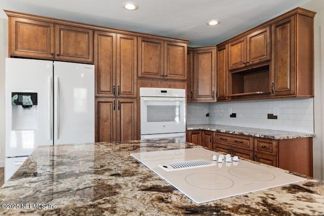 3060 Lewis Speedway, Saint Augustine, FL 32084 - kitchen with white appliances, light stone countertops, brown cabinetry, decorative backsplash, and recessed lighting