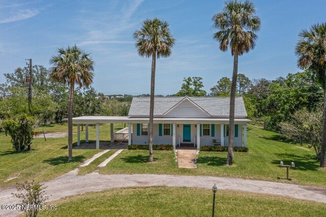 3060 Lewis Speedway, Saint Augustine, FL 32084 - view of front of house with driveway, a porch, a front yard, and an attached carport