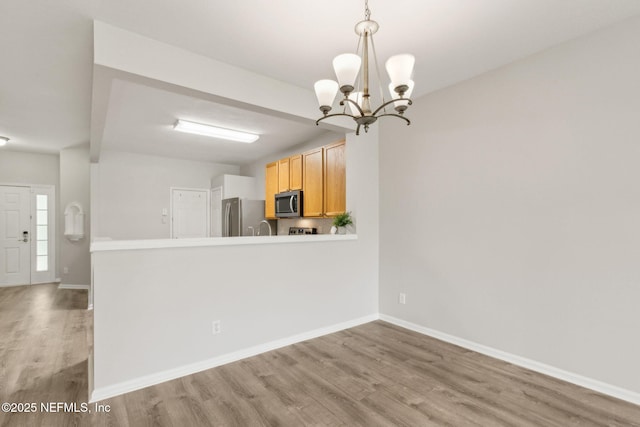 7990 Baymeadows Rd Unit 2404, Jacksonville, FL 32256 - kitchen featuring stainless steel appliances, light wood-style floors, a chandelier, and baseboards