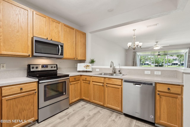 7990 Baymeadows Rd Unit 2404, Jacksonville, FL 32256 - kitchen featuring appliances with stainless steel finishes, a sink, a peninsula, light wood-type flooring, and a chandelier