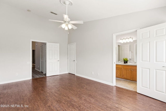 7990 Baymeadows Rd Unit 2404, Jacksonville, FL 32256 - unfurnished bedroom with light wood-type flooring, baseboards, a towering ceiling, ensuite bathroom, and a sink