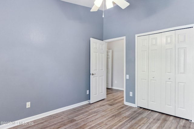 7990 Baymeadows Rd Unit 2404, Jacksonville, FL 32256 - unfurnished bedroom with wood finished floors, baseboards, a closet, a high ceiling, and ceiling fan