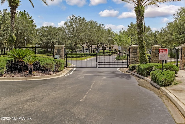 7990 Baymeadows Rd Unit 2404, Jacksonville, FL 32256 - view of asphalt road featuring a gate, curbs, and a gated entry
