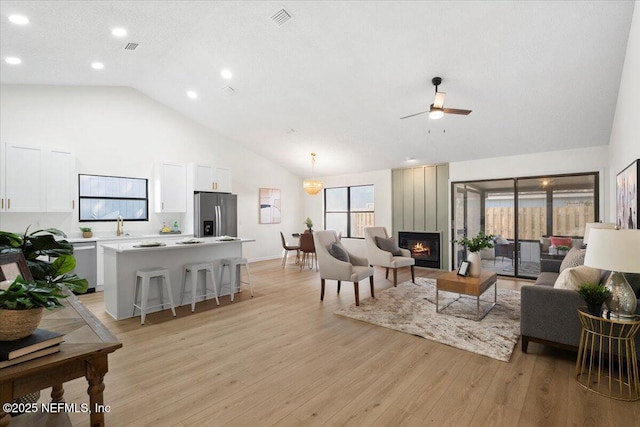 2767 Laten Ln, Jacksonville, FL 32216 - living room featuring light wood-style flooring, recessed lighting, a ceiling fan, a large fireplace, and high vaulted ceiling