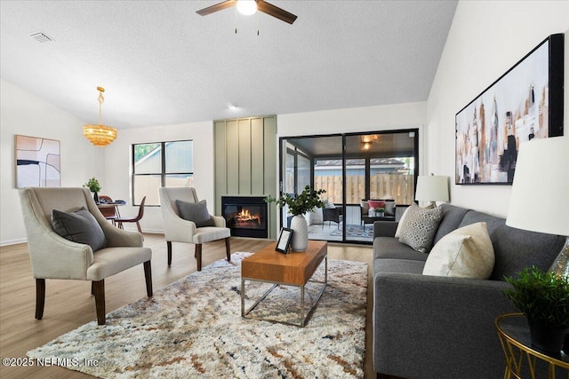 2767 Laten Ln, Jacksonville, FL 32216 - living room featuring wood finished floors, a textured ceiling, ceiling fan, a fireplace, and lofted ceiling