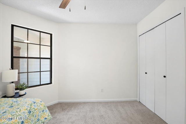 2767 Laten Ln, Jacksonville, FL 32216 - unfurnished bedroom featuring carpet flooring, a textured ceiling, a closet, baseboards, and ceiling fan