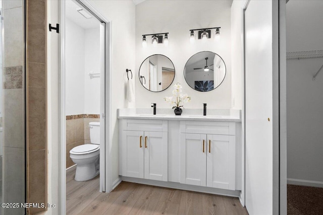 2767 Laten Ln, Jacksonville, FL 32216 - full bath with toilet, double vanity, wood finished floors, a ceiling fan, and a closet