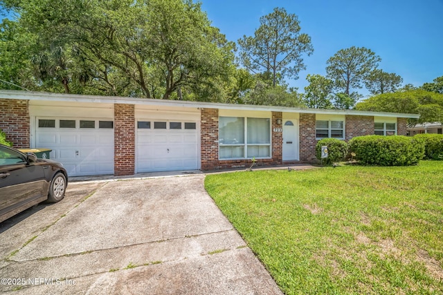 723 Montego Rd W, Jacksonville, FL 32216 - ranch-style home featuring driveway, an attached garage, a front yard, and brick siding