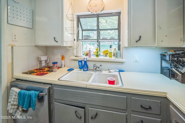 723 Montego Rd W, Jacksonville, FL 32216 - kitchen with gray cabinetry, a sink, stainless steel dishwasher, and light countertops