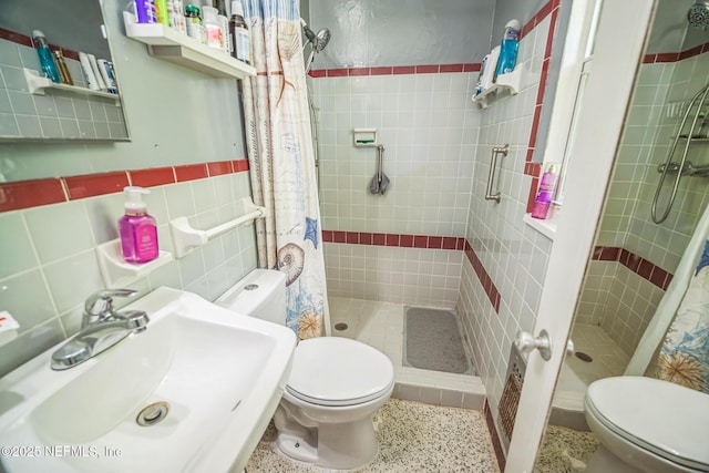 723 Montego Rd W, Jacksonville, FL 32216 - full bathroom with toilet, tile walls, a stall shower, a sink, and speckled floor