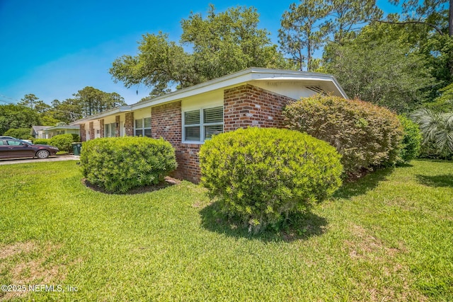 723 Montego Rd W, Jacksonville, FL 32216 - view of side of home with brick siding and a lawn