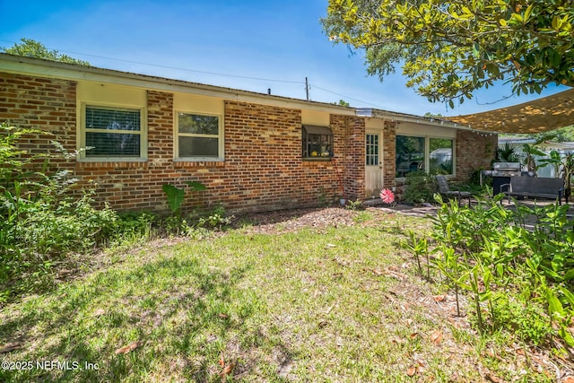 723 Montego Rd W, Jacksonville, FL 32216 - back of property featuring brick siding and a yard