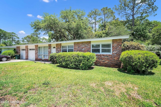 723 Montego Rd W, Jacksonville, FL 32216 - view of front of home featuring a garage, brick siding, a front yard, and concrete driveway