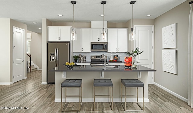 77 Elm Creek Dr, Saint Augustine, FL 32092 - kitchen with stainless steel appliances, dark countertops, a sink, light wood finished floors, and recessed lighting