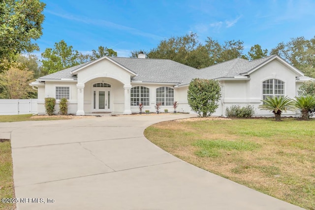 4833 Saddlehorn Trl, Middleburg, FL 32068 - ranch-style house with stucco siding, curved driveway, a chimney, and roof with shingles