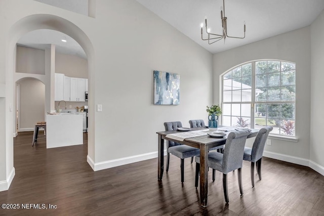 4833 Saddlehorn Trl, Middleburg, FL 32068 - dining area with a chandelier, high vaulted ceiling, arched walkways, dark wood-type flooring, and baseboards
