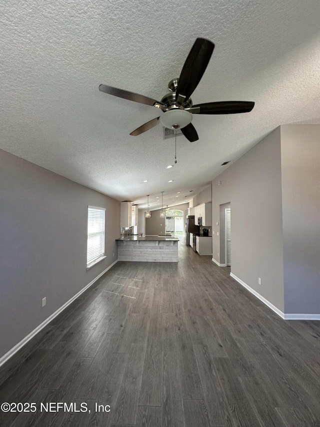 1456 Greenway Pl, Fleming Island, FL 32003 - unfurnished living room featuring ceiling fan, a textured ceiling, dark wood-type flooring, and baseboards