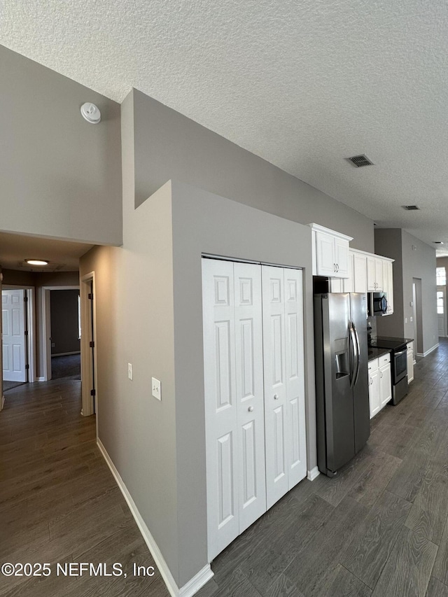 1456 Greenway Pl, Fleming Island, FL 32003 - kitchen with appliances with stainless steel finishes, dark wood-style floors, white cabinetry, a textured ceiling, and baseboards