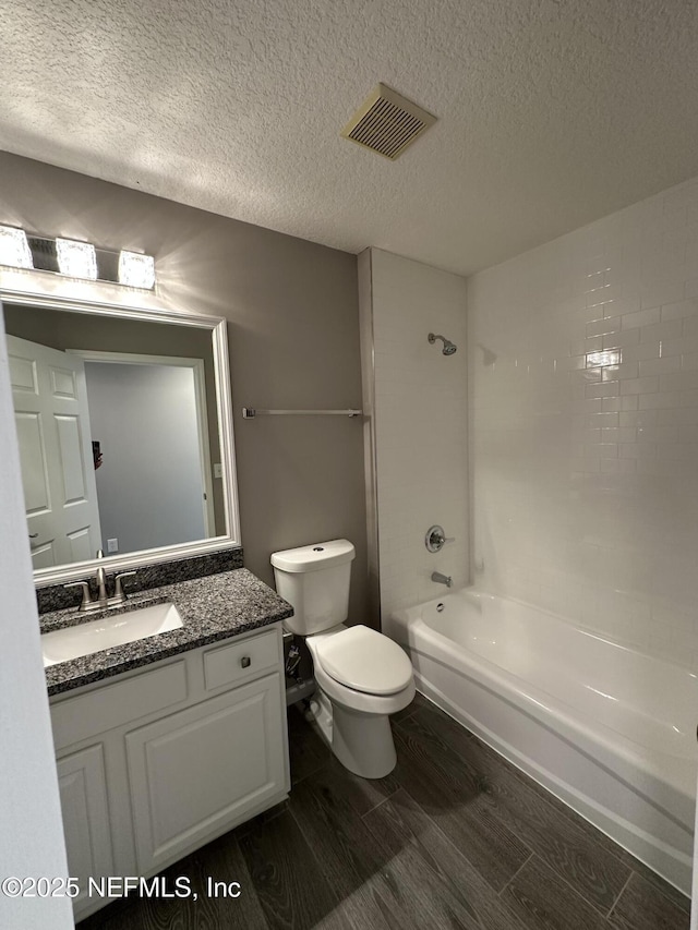 1456 Greenway Pl, Fleming Island, FL 32003 - full bath featuring a textured ceiling, toilet, wood finish floors, vanity, and shower / tub combination