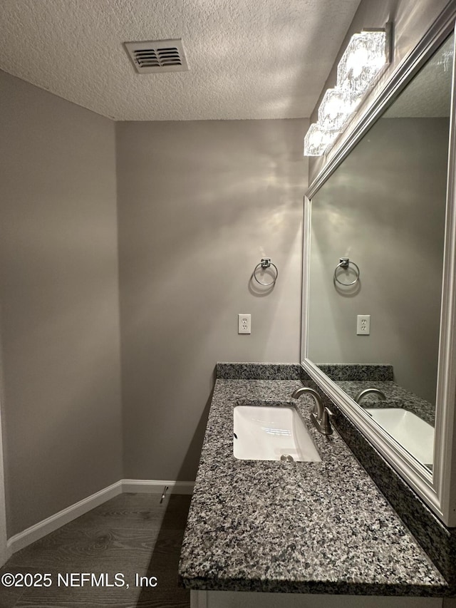 1456 Greenway Pl, Fleming Island, FL 32003 - bathroom featuring a textured ceiling, vanity, baseboards, and wood finished floors