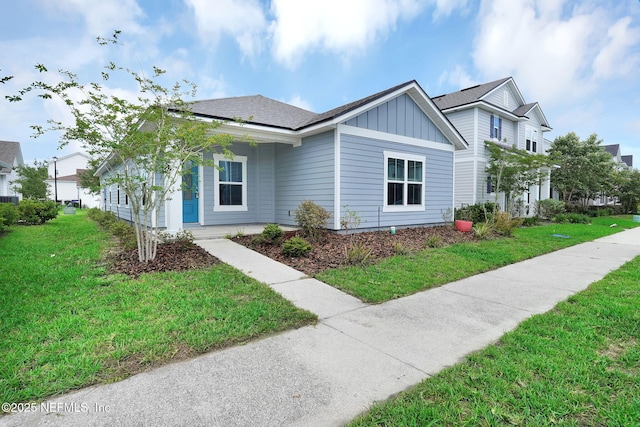 328 Clarys Run, Saint Augustine, FL 32092 - view of front of house featuring board and batten siding, a front yard, and roof with shingles