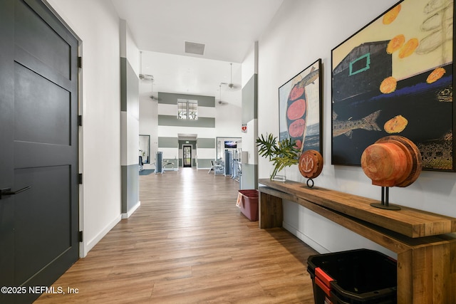 328 Clarys Run, Saint Augustine, FL 32092 - hall with light wood finished floors, a towering ceiling, and baseboards