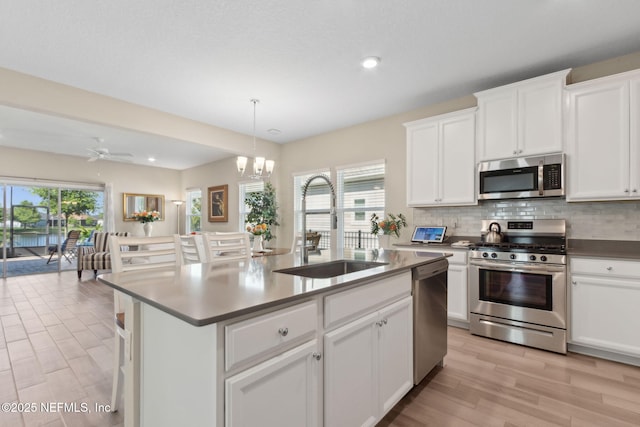 267 Ash Breeze Cv, Saint Augustine, FL 32095 - kitchen featuring stainless steel appliances, a sink, backsplash, light wood-style floors, and white cabinets
