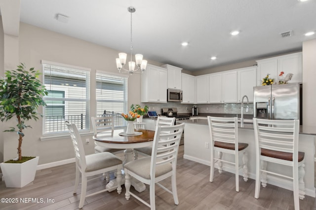 267 Ash Breeze Cv, Saint Augustine, FL 32095 - dining room with a chandelier, light wood finished floors, recessed lighting, and baseboards