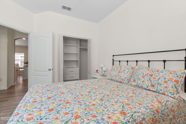 267 Ash Breeze Cv, Saint Augustine, FL 32095 - bedroom with arched walkways, wood finished floors, a closet, lofted ceiling, and baseboards