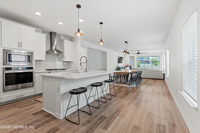 32 Mosaic Park Ave, Saint Augustine, FL 32092 - kitchen featuring appliances with stainless steel finishes, wall chimney exhaust hood, a sink, open floor plan, and recessed lighting