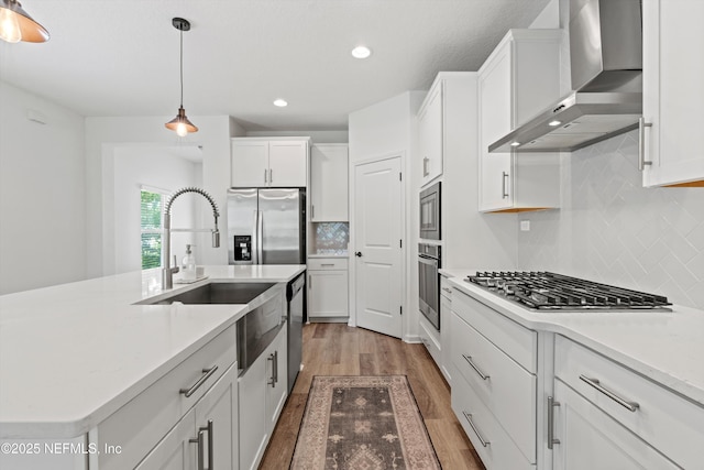 32 Mosaic Park Ave, Saint Augustine, FL 32092 - kitchen with wall chimney exhaust hood, appliances with stainless steel finishes, light wood-style flooring, white cabinets, and recessed lighting