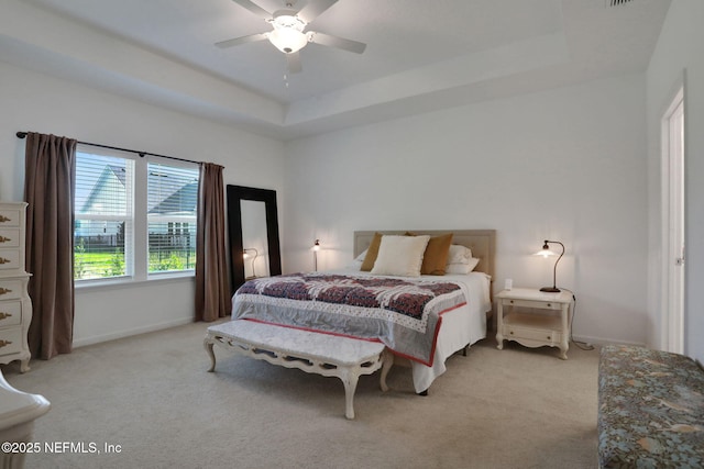 84754 Fall River Pkwy, Fernandina Beach, FL 32034 - bedroom with light carpet, a tray ceiling, baseboards, and ceiling fan