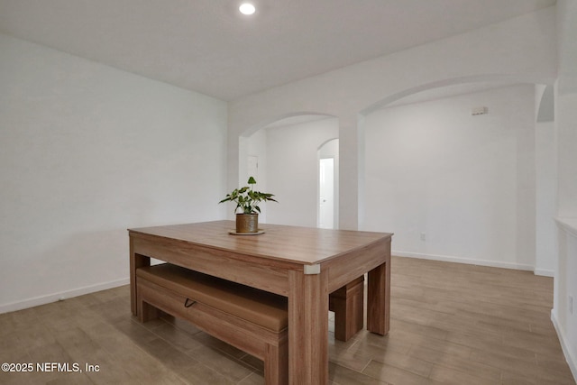 84754 Fall River Pkwy, Fernandina Beach, FL 32034 - dining room with arched walkways, light wood-style flooring, baseboards, and recessed lighting