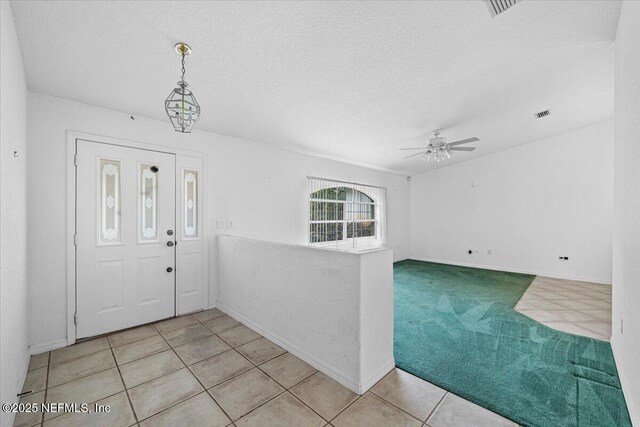 30 Patuxent Ln, Palm Coast, FL 32164 - entryway featuring a ceiling fan, light tile patterned floors, light carpet, a textured ceiling, and baseboards