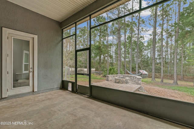 1098 Spanish Bay Ct, Orange Park, FL 32065 - unfurnished sunroom with an outdoor fire pit and view of wooded area